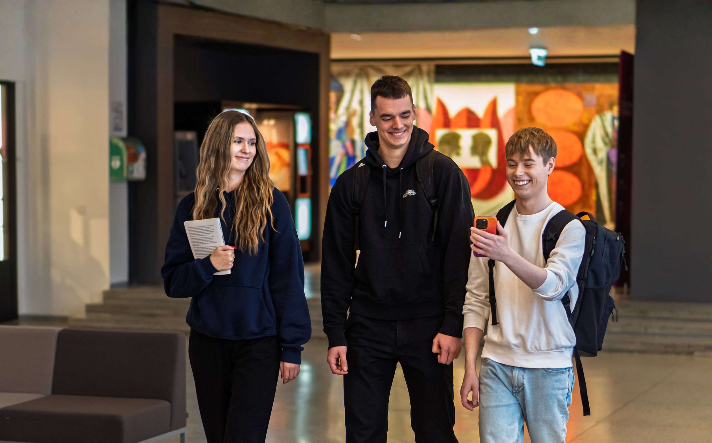 Kolm naeratavat üliõpilast vaatavad koos nutitelefoni — Unisteps 2026 Euroopa ülikoolide sammuväljakutse